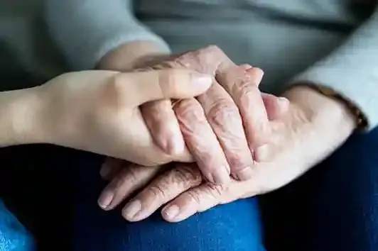 Family members holding hands after someone dies while using Evaheld for first 48 hour planning