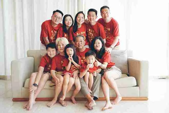 A big multi-generational family all wearing red t-shirts and posing for a family photo